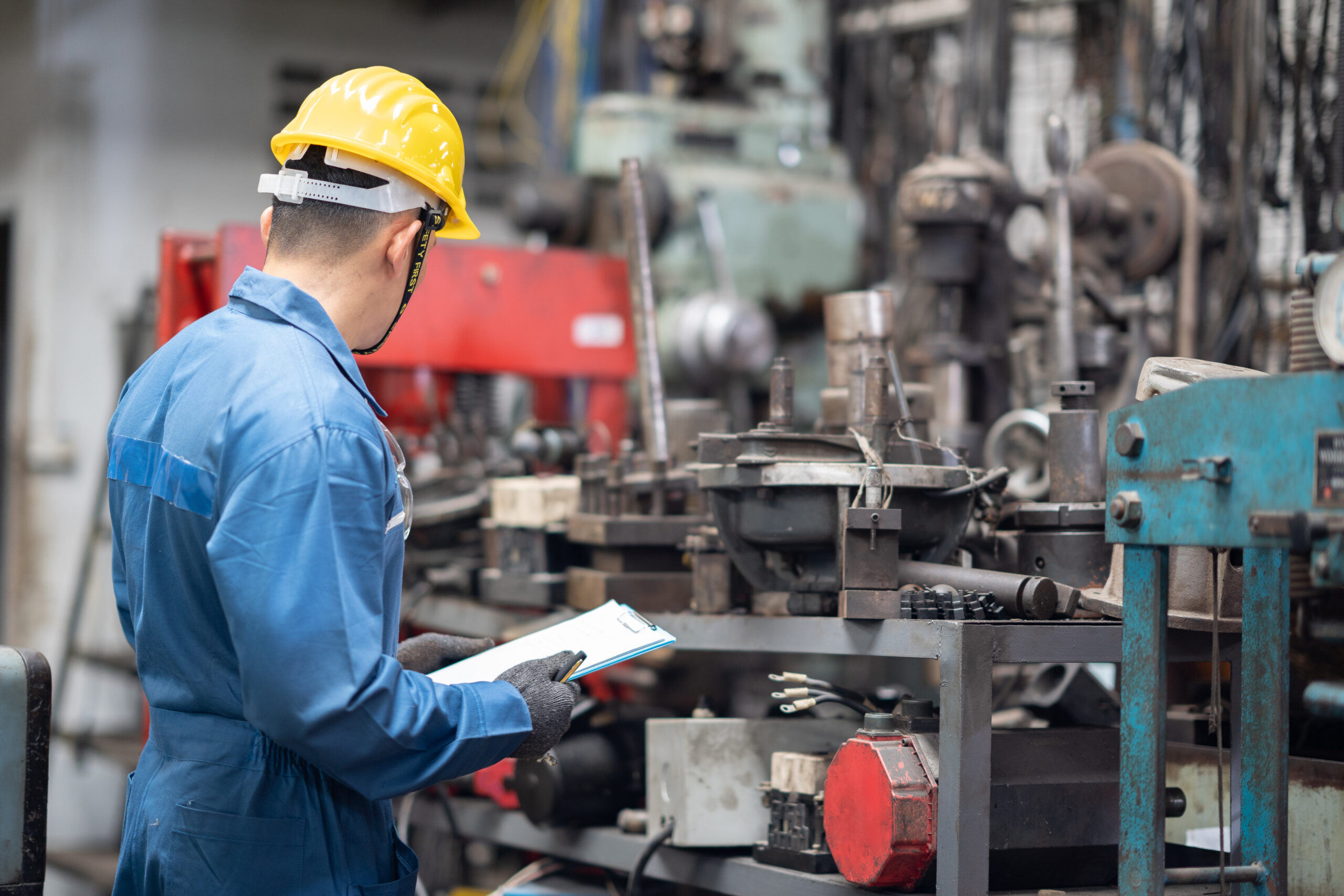Industrial Manufacturing, male worker looking at machinery
