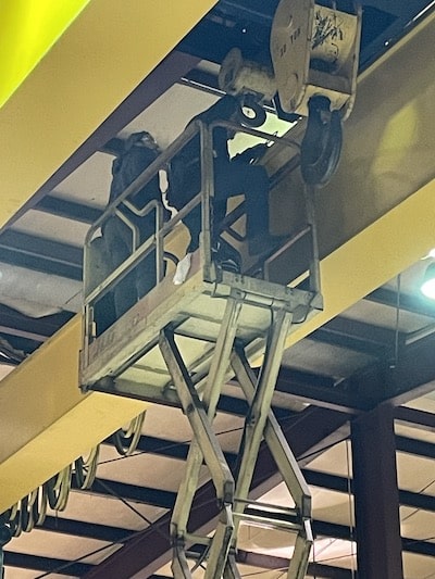 Construction workers working on an overhead crane