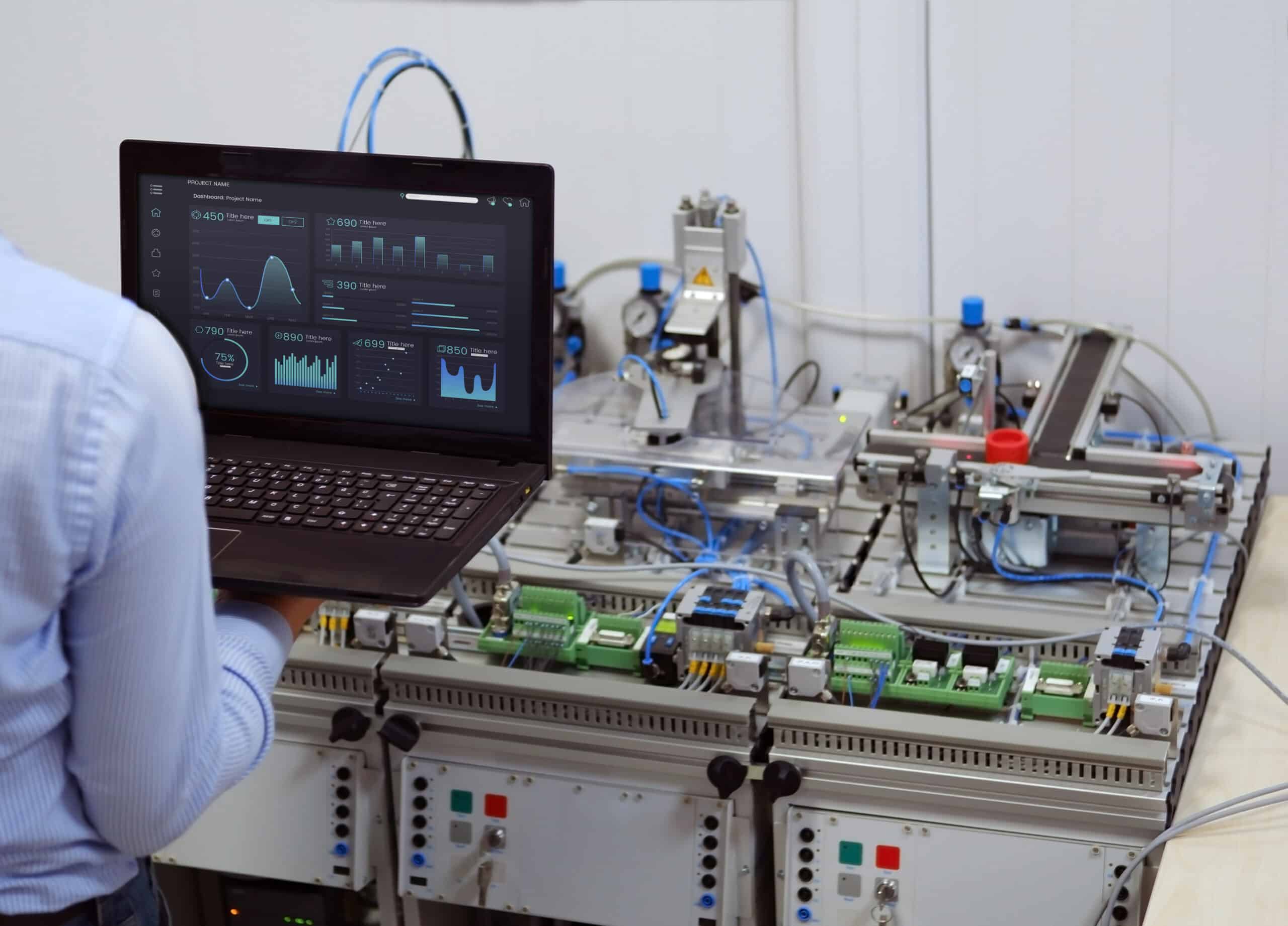 Engineer is programming PLC with his laptop for a smart factory